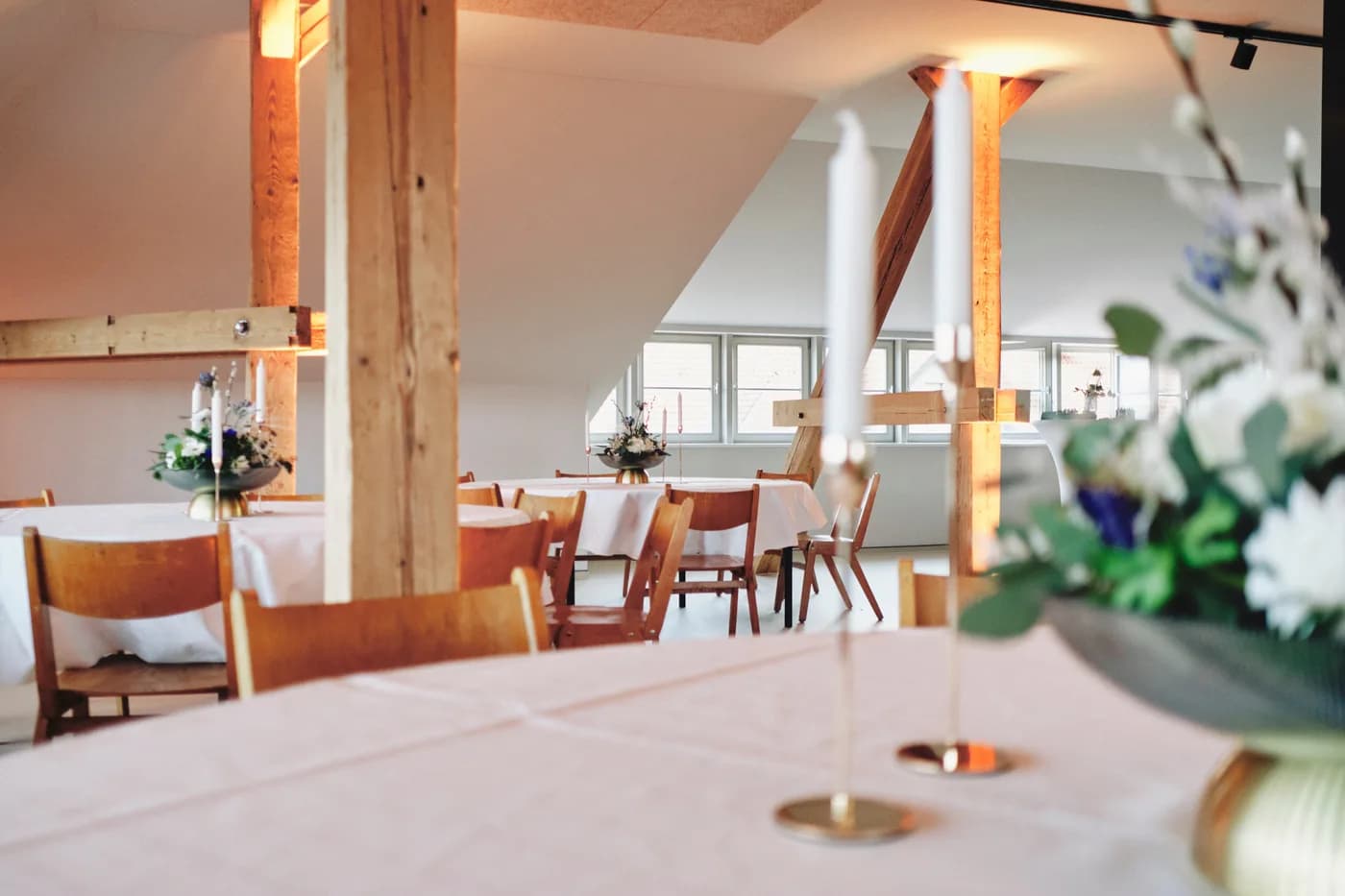Gedeckter Tisch mit Kerzen und Blumen in der Eventlocation Petersberg